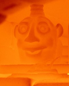 Alkaline face jug midway through firing in wood-fired kiln